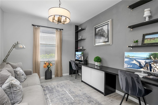 home office with built in study area and baseboards