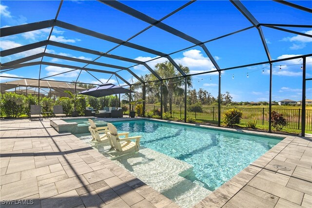 view of swimming pool with outdoor lounge area, glass enclosure, and a patio