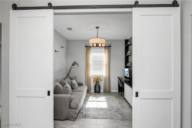 living room with a barn door and light hardwood / wood-style floors