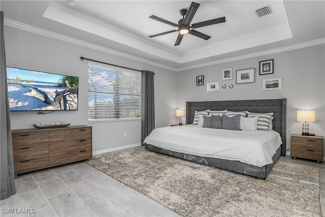 bedroom with a tray ceiling, ceiling fan, and ornamental molding