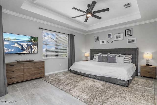 bedroom with visible vents, baseboards, crown molding, and a tray ceiling