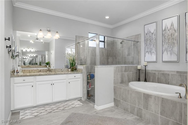 bathroom with a garden tub, vanity, ornamental molding, and a shower stall