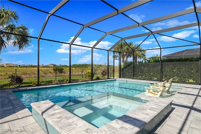 view of swimming pool featuring glass enclosure, an in ground hot tub, and a patio area