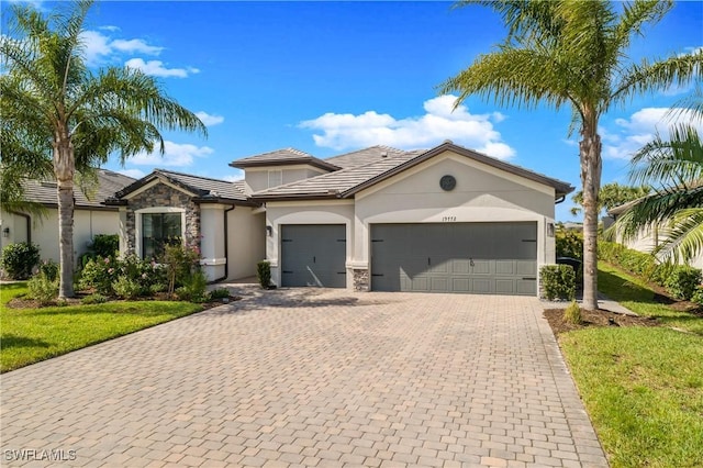 view of front of home with decorative driveway, a garage, and stone siding