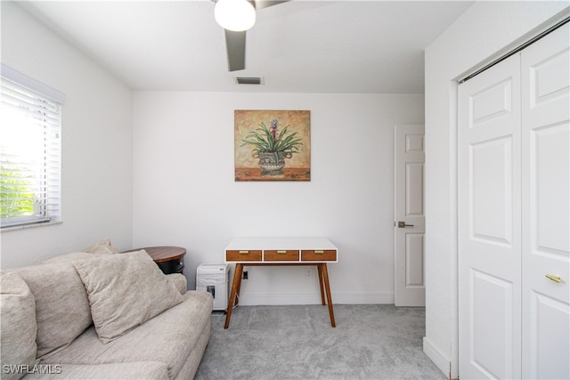 sitting room with ceiling fan and light colored carpet