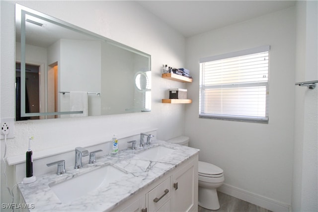 bathroom with vanity, toilet, and hardwood / wood-style flooring