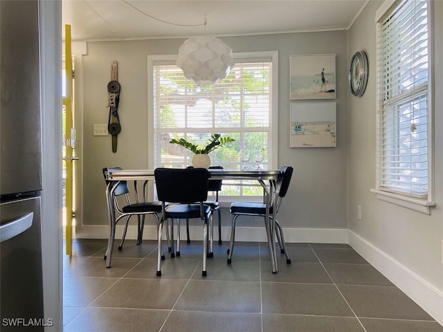 dining room featuring an inviting chandelier, tile patterned floors, and ornamental molding