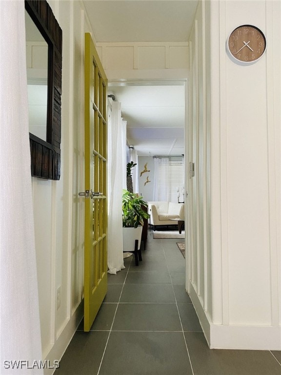 hallway featuring dark tile patterned floors