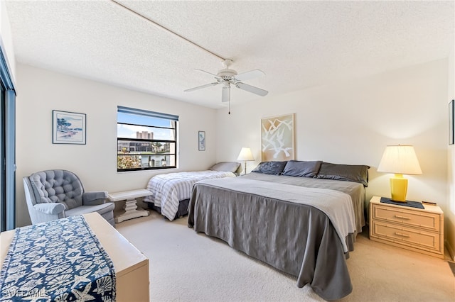 bedroom with light carpet, a textured ceiling, and ceiling fan