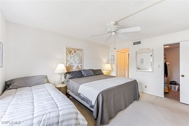 carpeted bedroom featuring a textured ceiling, a closet, and ceiling fan