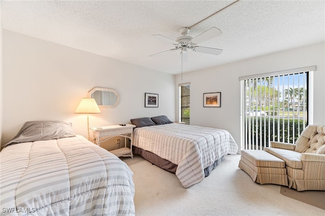 bedroom with a textured ceiling, access to exterior, carpet, and ceiling fan