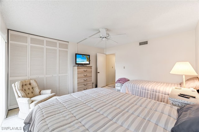 bedroom with a closet, a textured ceiling, and ceiling fan