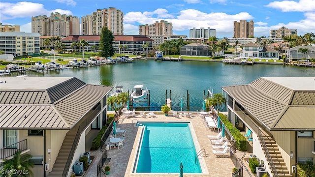 view of swimming pool with a patio area, a water view, and a water slide