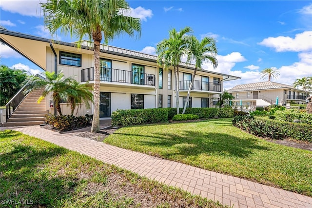 view of front of property with a front lawn and a balcony