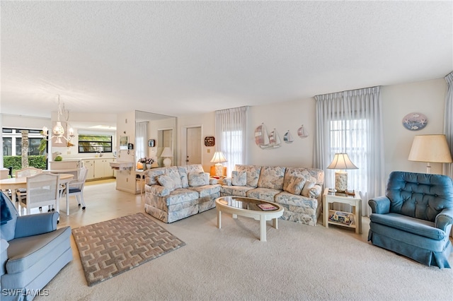 living room featuring a notable chandelier, a textured ceiling, and a healthy amount of sunlight