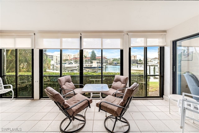 sunroom featuring a water view and a healthy amount of sunlight