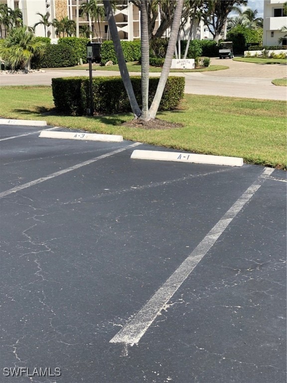 view of vehicle parking with a lawn