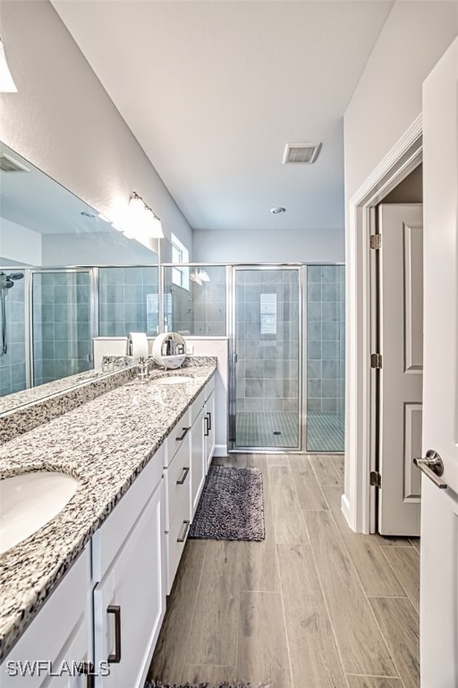 bathroom with walk in shower and vanity