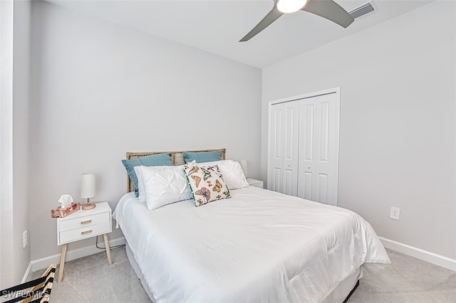 bedroom featuring ceiling fan, light colored carpet, and a closet