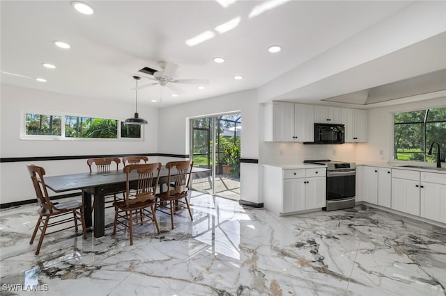 kitchen featuring decorative backsplash, ceiling fan, white cabinetry, stainless steel range oven, and decorative light fixtures