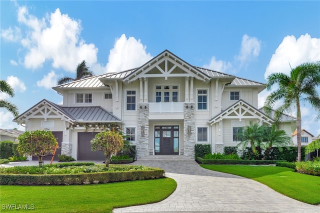 craftsman inspired home with a standing seam roof, stone siding, and a front yard
