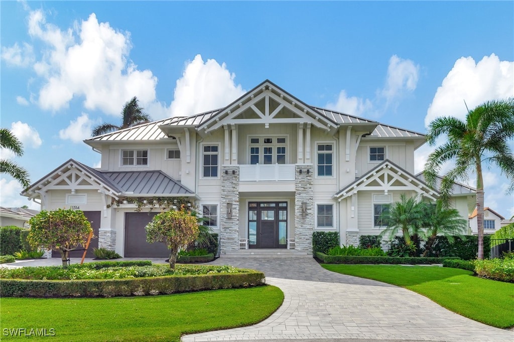 1314 Marlin Dr, Naples, FL 34102 - craftsman inspired home with a standing seam roof, stone siding, and a front yard