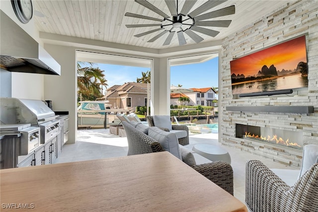 living room with tile patterned flooring, a ceiling fan, an outdoor stone fireplace, and a residential view