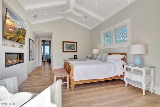 bedroom with light wood-type flooring, a glass covered fireplace, baseboards, and wooden ceiling