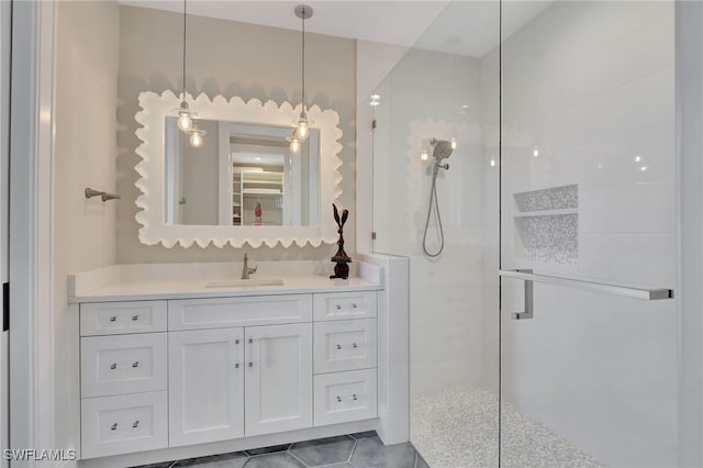 bathroom with a walk in shower, vanity, and tile patterned floors