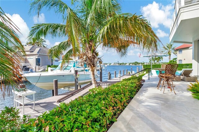 view of patio featuring a water view and a dock