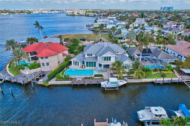 aerial view of residential area with a nearby body of water and a pool area