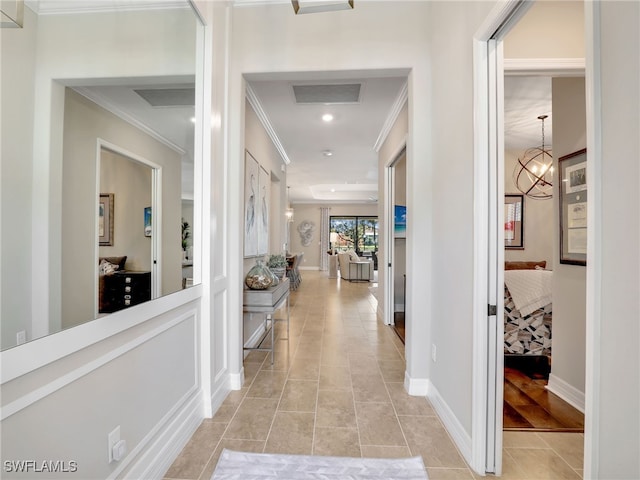 hall with crown molding, light tile patterned flooring, and an inviting chandelier