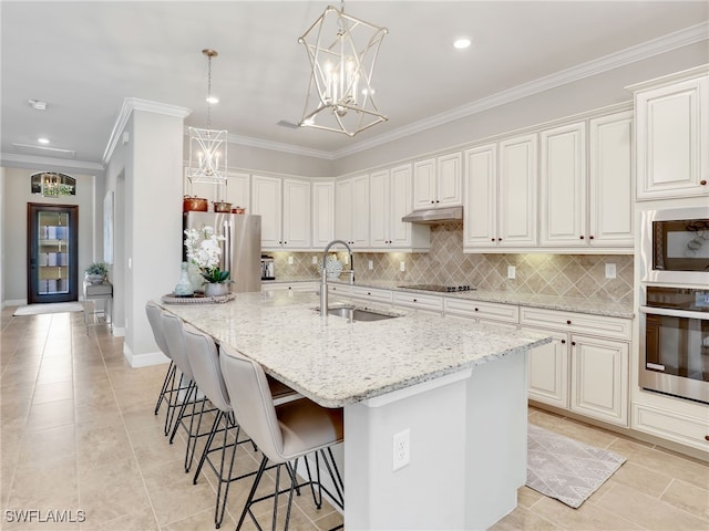 kitchen with a center island with sink, sink, appliances with stainless steel finishes, and white cabinets