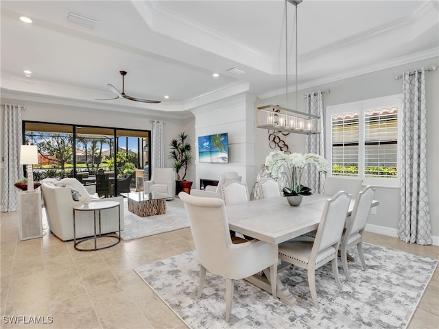 dining space with crown molding, a tray ceiling, plenty of natural light, and ceiling fan