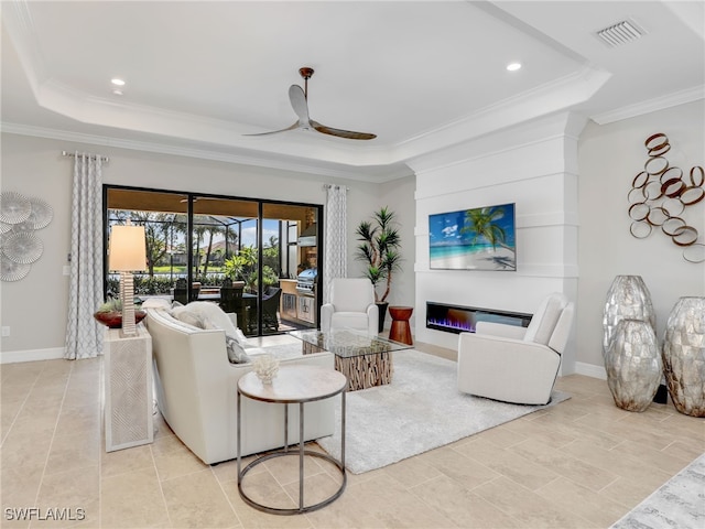 tiled living room with ornamental molding, a raised ceiling, and ceiling fan