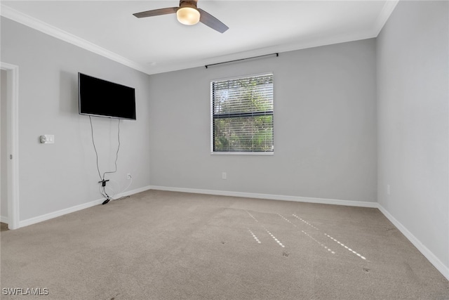 spare room featuring ornamental molding, light colored carpet, and ceiling fan