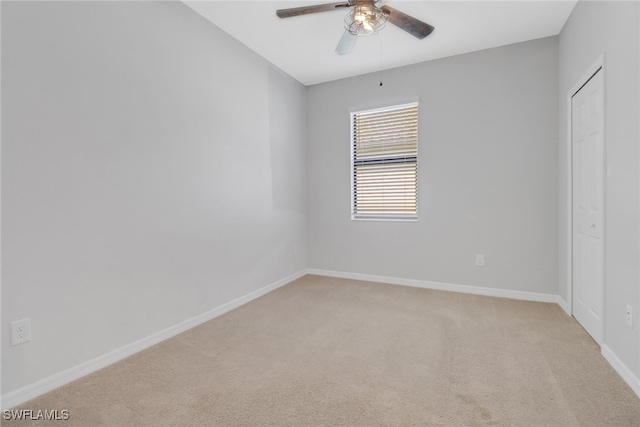 carpeted spare room with ceiling fan