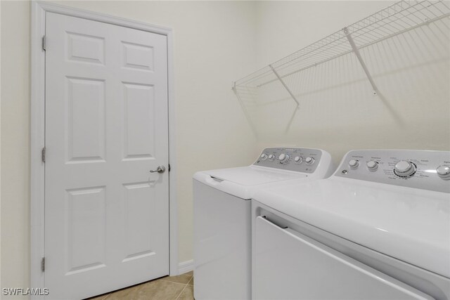 laundry area featuring washer and dryer and light tile patterned flooring