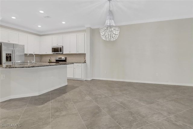 kitchen with appliances with stainless steel finishes, a notable chandelier, white cabinets, and hanging light fixtures