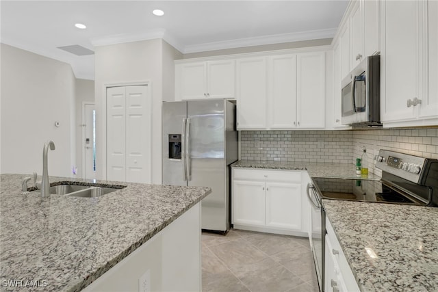 kitchen with stainless steel appliances, light stone countertops, and white cabinets