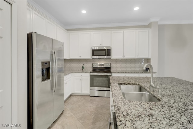 kitchen featuring stainless steel appliances, ornamental molding, sink, light stone countertops, and white cabinets