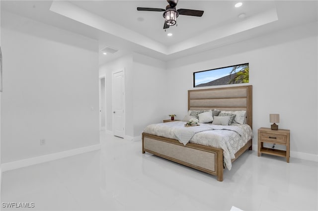 bedroom with ceiling fan, a raised ceiling, and tile patterned flooring