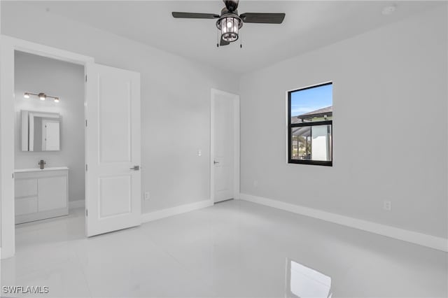 unfurnished bedroom with ensuite bathroom, light tile patterned floors, and ceiling fan