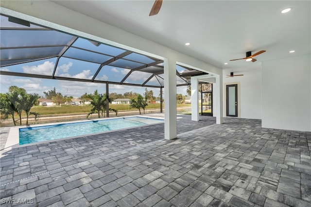 view of pool featuring a patio area, ceiling fan, and glass enclosure