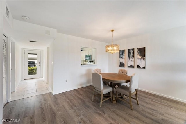 dining area with hardwood / wood-style flooring and a chandelier