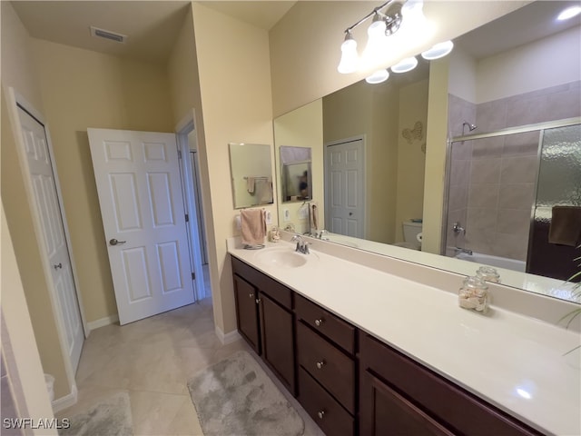 full bathroom featuring tiled shower / bath, vanity, toilet, and tile patterned floors