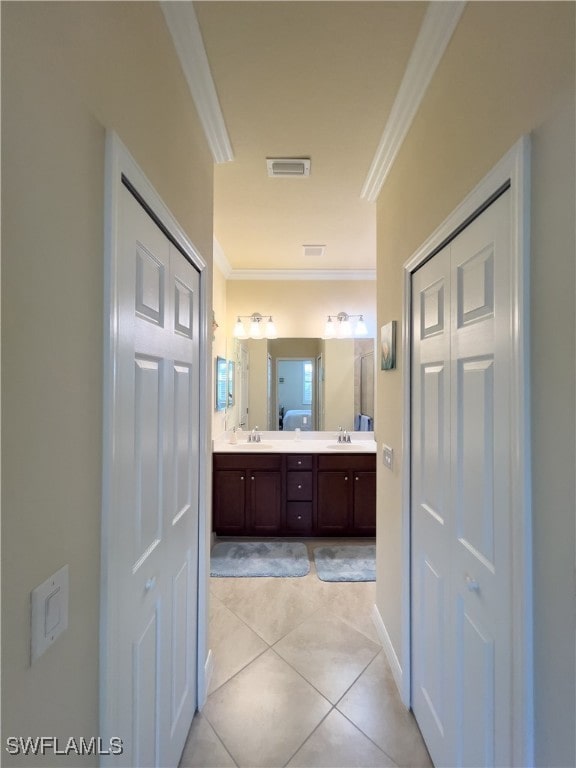 bathroom with crown molding, tile patterned floors, and vanity