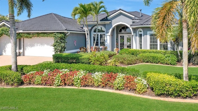 view of front of home with a garage and a front lawn