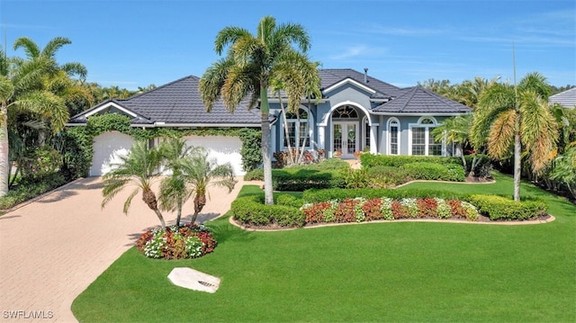 view of front of house with french doors, a garage, and a front lawn