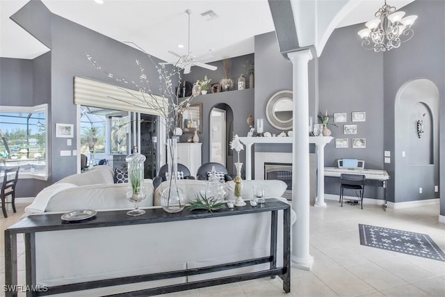 living room with decorative columns, a high ceiling, light tile patterned floors, and ceiling fan